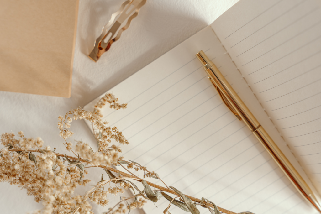 notebook with a flower and a golden pen
