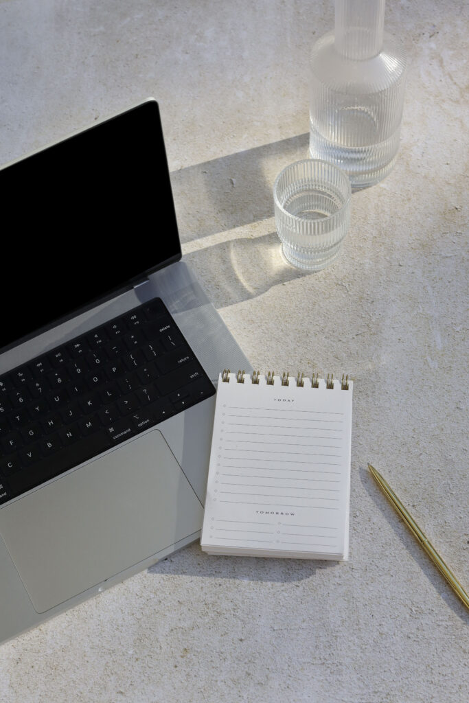 laptop with notepad and a glass of water