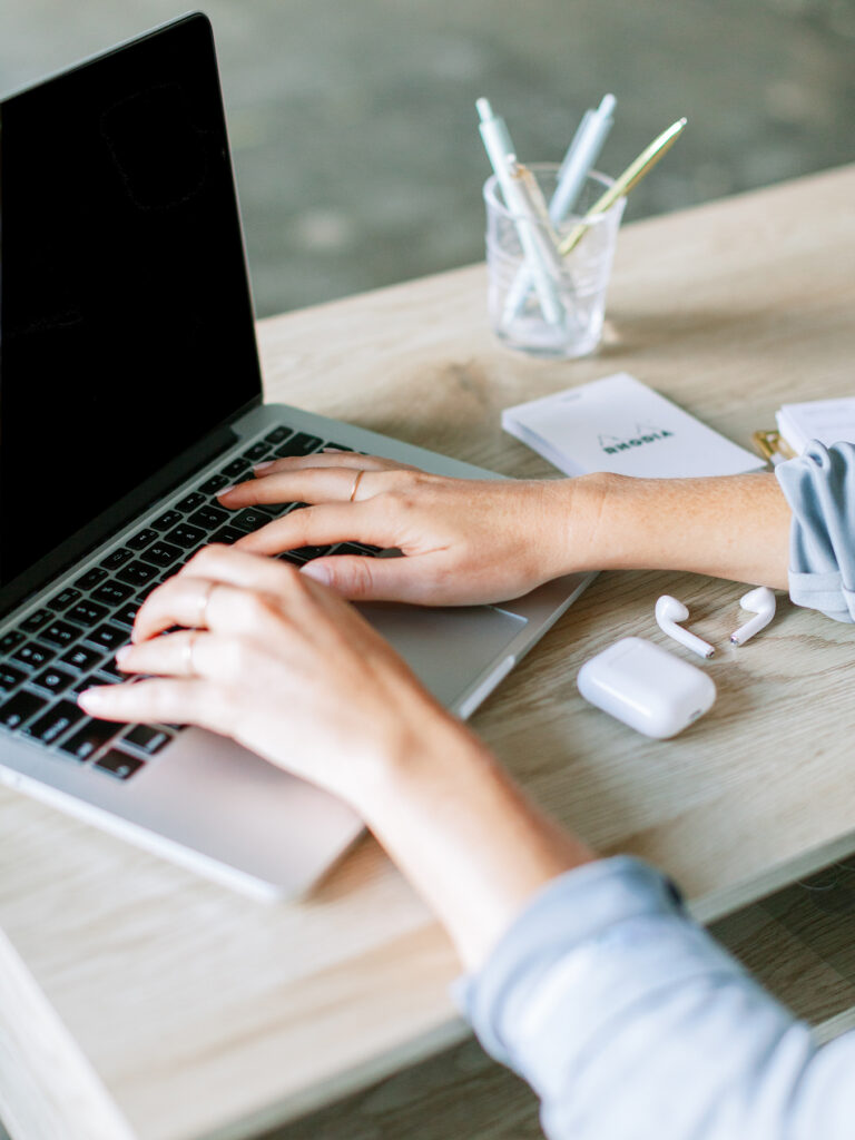 woman's hand typing on a laptop