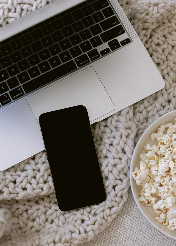 laptop with a phone and popcorn on the side - can i look at pinterest without an account