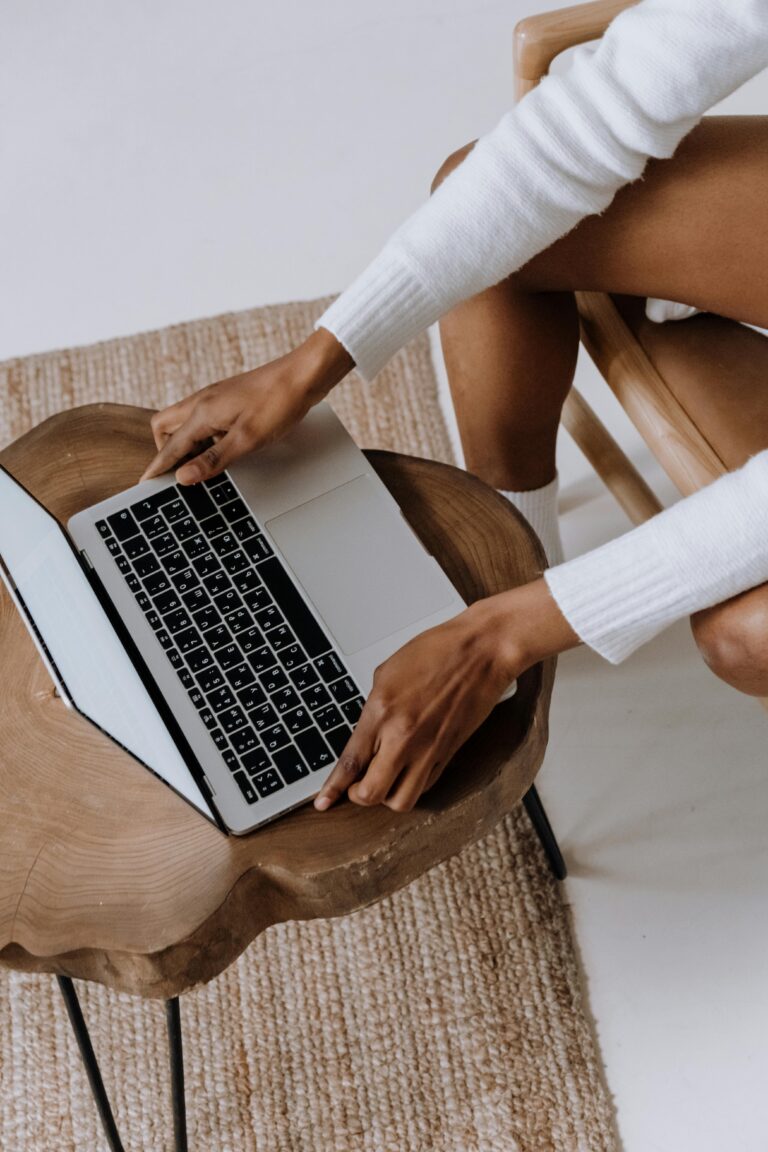 woman sitting on a chair and a laptop on top of a wooden table