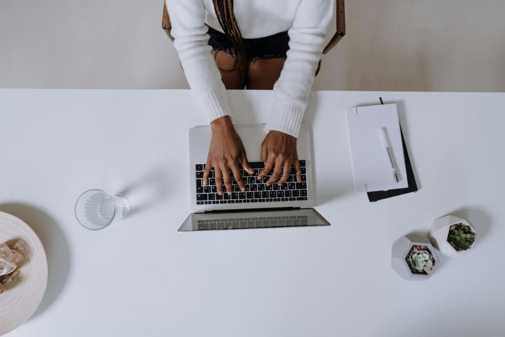 top view of a faceless woman with her hand on the laptop