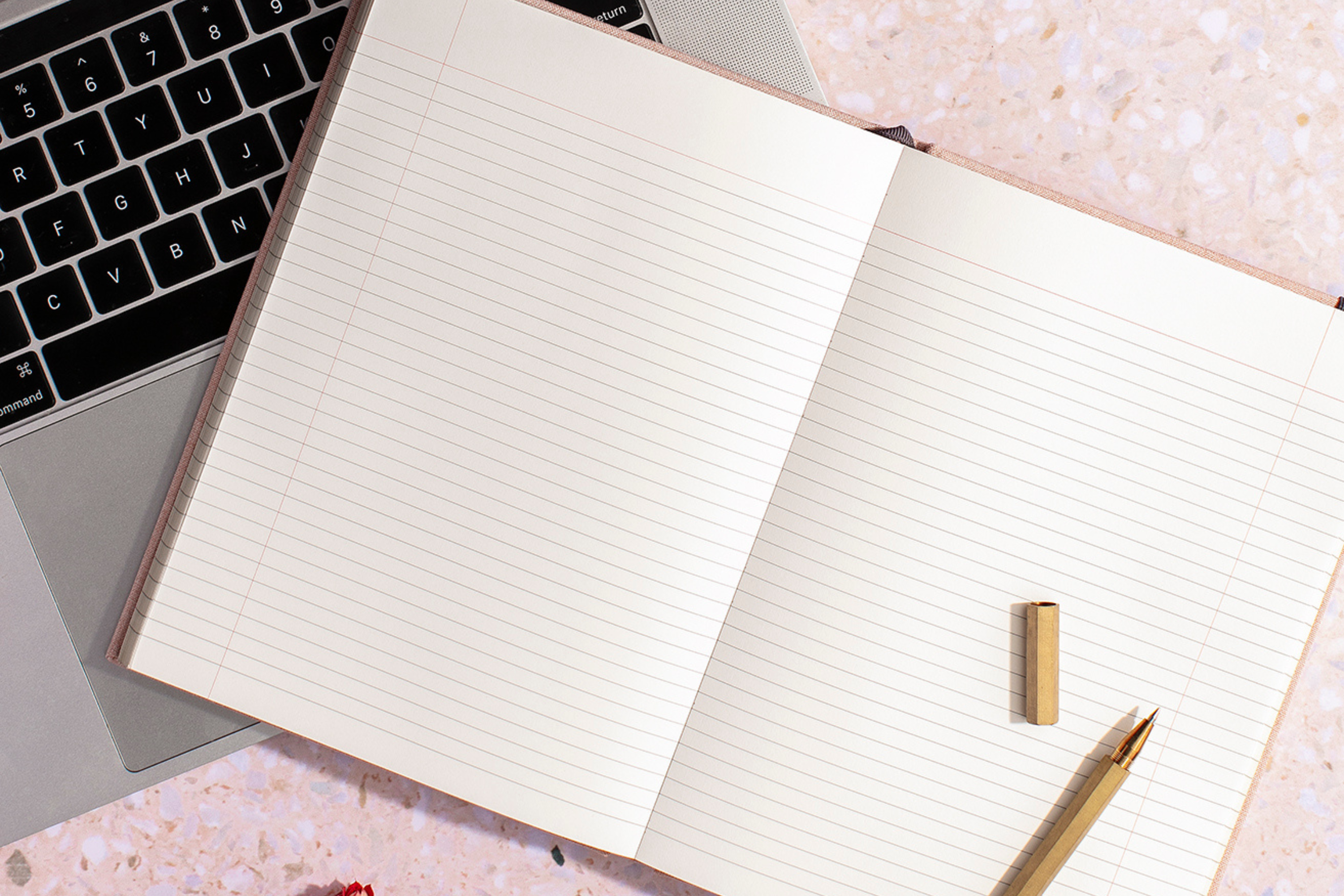 a notebook with a laptop and an uncapped pen