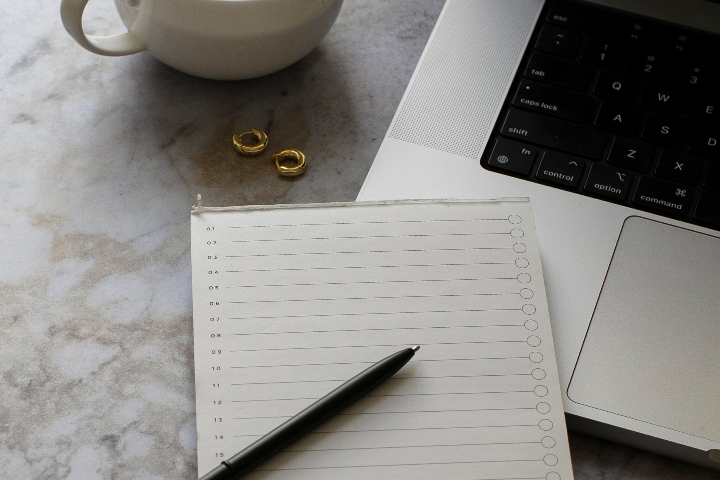 a notepad and pen on a laptop for organizing a blog