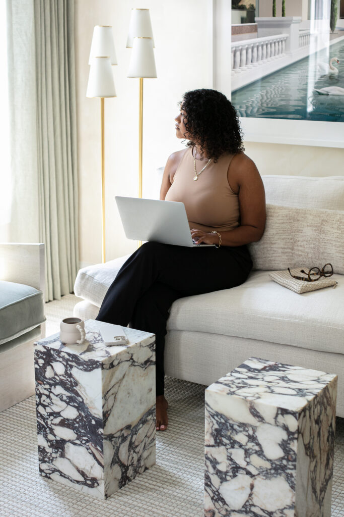 A women looking out the window while holding a laptop