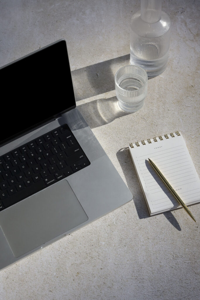 a laptop with a note pad - how to get your blog to show up in google