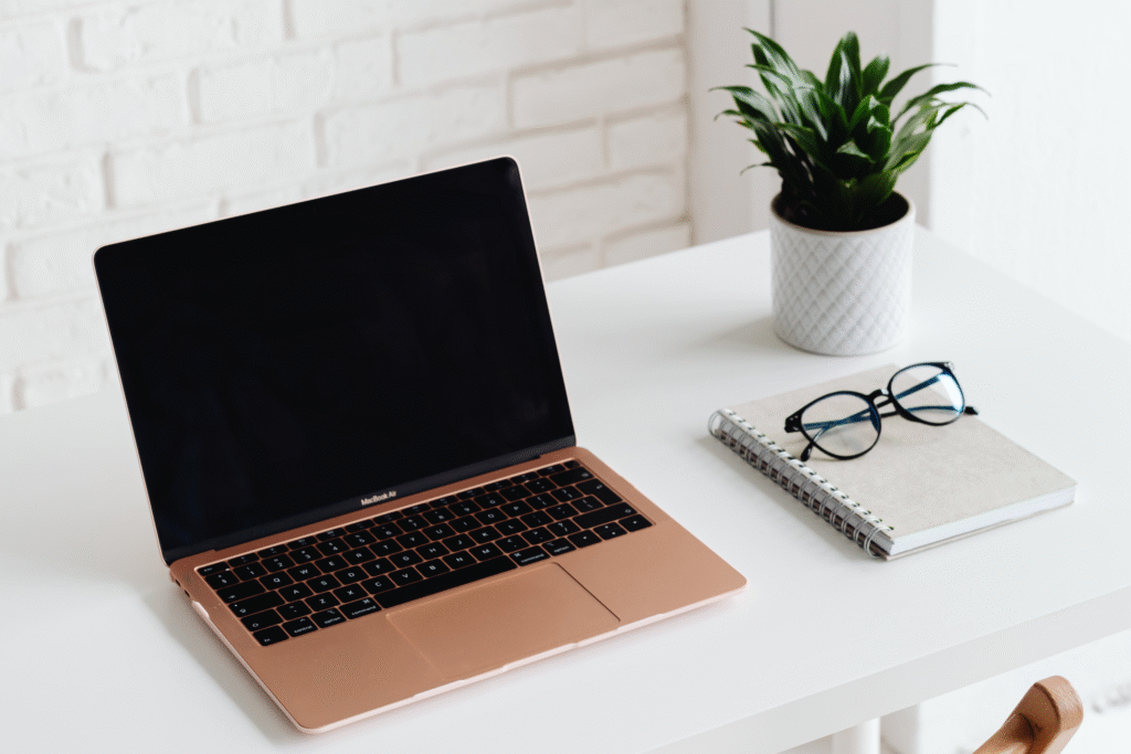 a laptop with glasses on top of a book