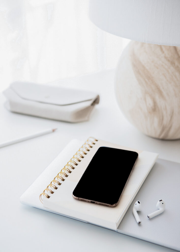 a phone on top of the notebook and laptop